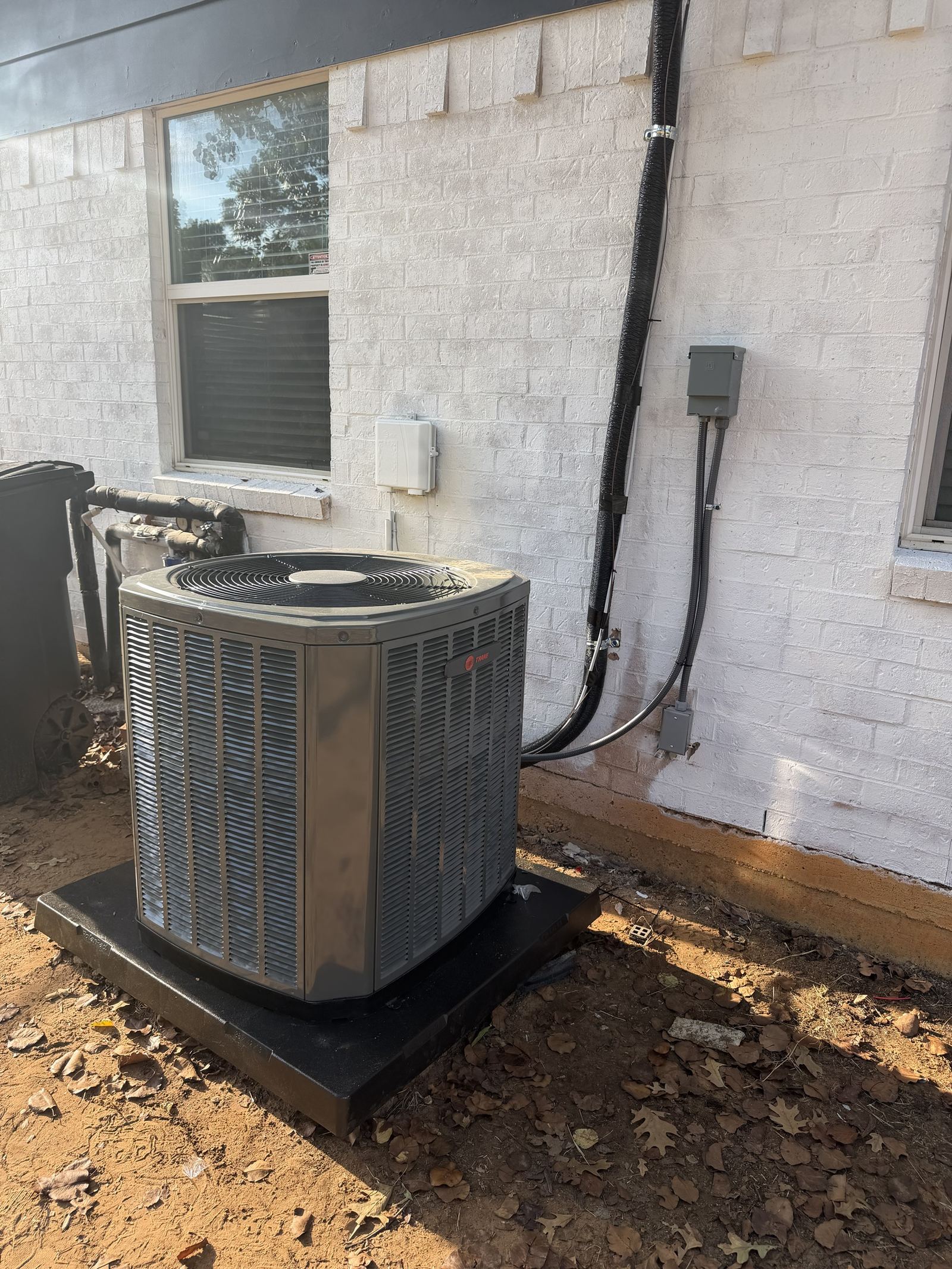 Trane condenser unit installed alongside home